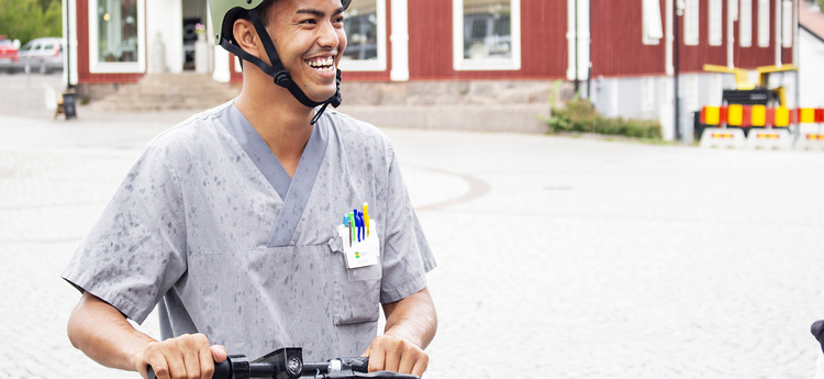 Hemtjänstmedarbetare på sparkcykel.