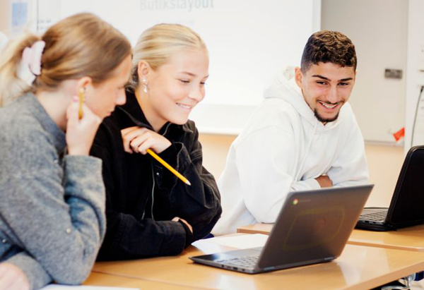Tre unga personer vid en laptop.