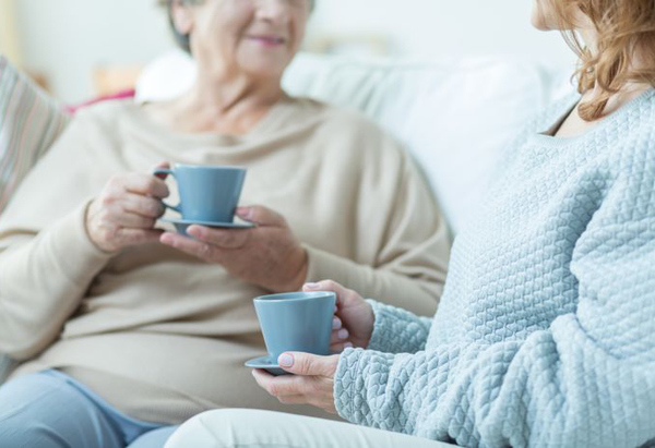 Äldre och yngre kvinna som sitter i en soffa.