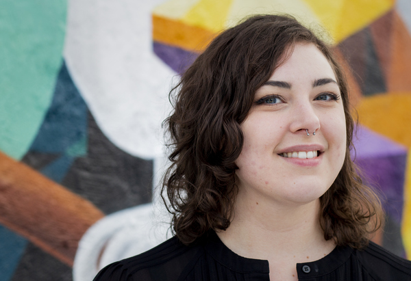 Jenny framför väggmålning på Kulturskolans fasad.