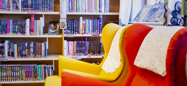 Bokhyllor och fåtöljer på Alléskolans bibliotek.