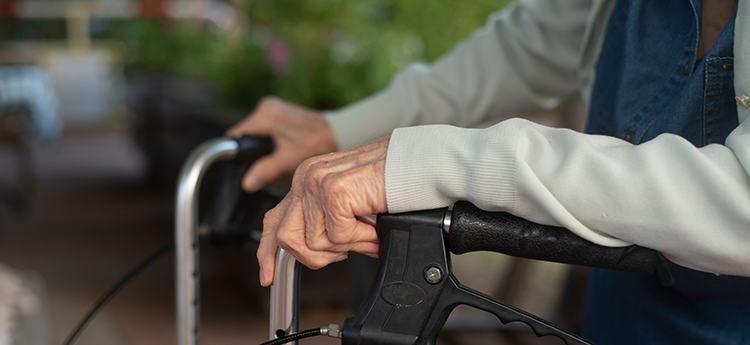 Äldre person med rollator.