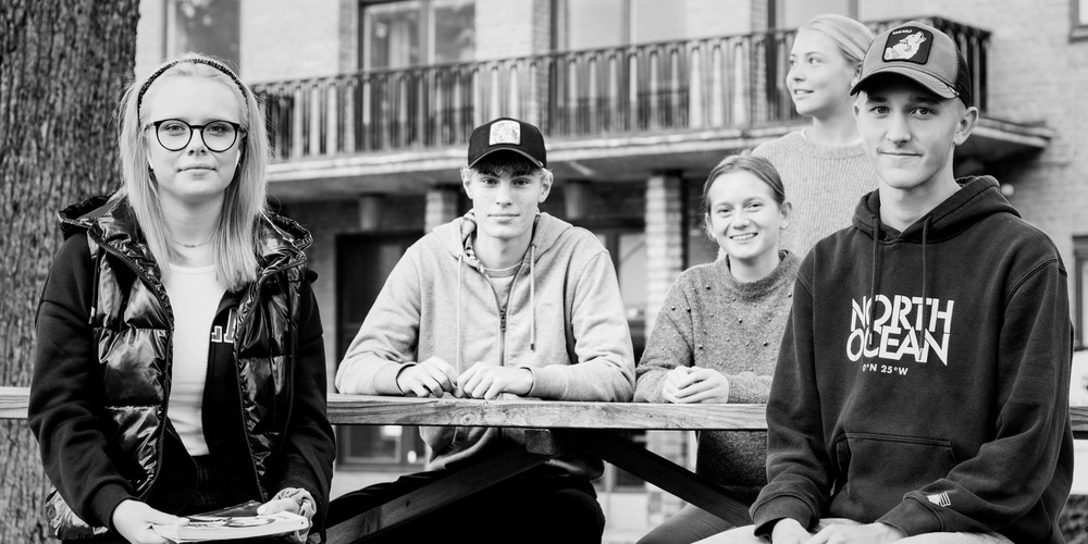 Gymnasieelever på bänk utanför Bildningscentrum Facetten.